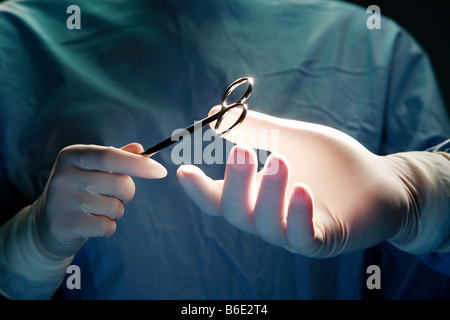 La chirurgie. Assistantpassing chirurgie forceps pour un chirurgien lors d'une opération Banque D'Images