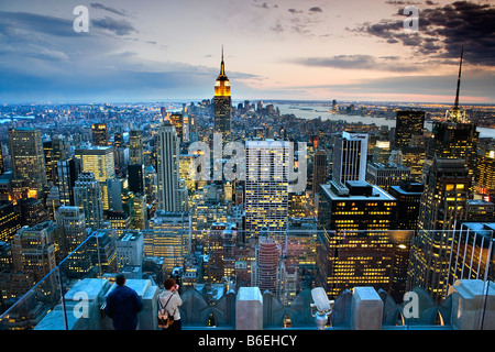 USA, New York, Manhattan, les touristes de prendre une photographie du Rockefeller Center de Manhattan illuminé et Empire State Building Banque D'Images