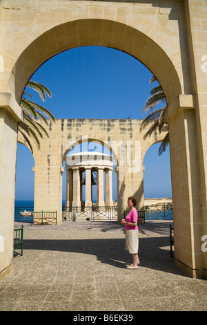 Bell siège Monument, Monument commémoratif de la Seconde Guerre mondiale, à travers les arches, Jardins Barracca inférieur, La Valette, Malte Banque D'Images