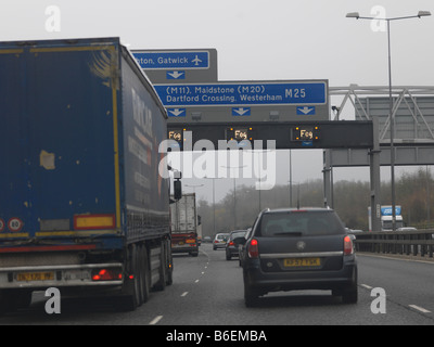 La circulation sur autoroute M25 dans le Surrey avec panneaux d'avertissement de brouillard Banque D'Images