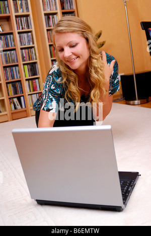 Jeune femme travaillant à la maison sur son ordinateur portable Banque D'Images