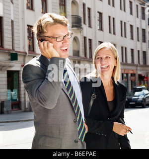 L'homme sur le mobile et woman holding pen Banque D'Images