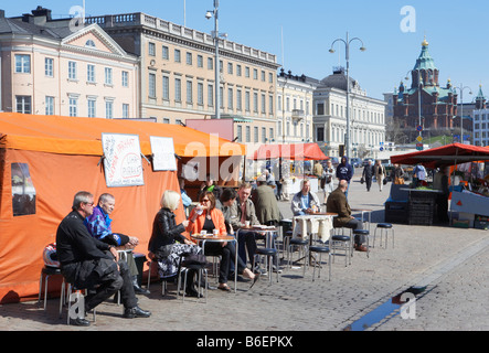 Les gens de manger et boire à l'un des étals de la place du marché, la cathédrale Uspenski en arrière-plan Helsinki Finlande Banque D'Images