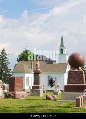 Cimetière rural en mettant l'accent sur l'église ronde de stèles avec en arrière-plan Banque D'Images