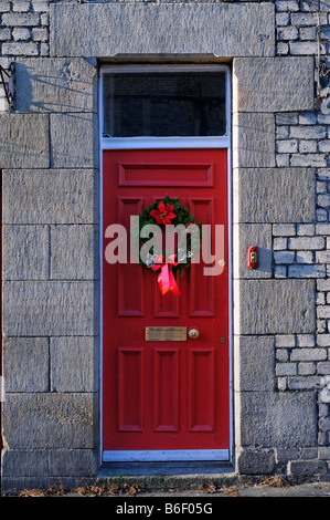 Porte avant rouge avec couronne de Noël Banque D'Images