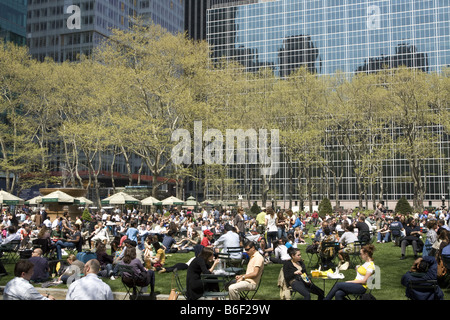 Les employés de bureau ainsi qu'aux touristes profiter d'un printemps chaud jour, à l'heure du midi dans la région de Bryant Park derrière le NY Public Library À NEW YORK Banque D'Images