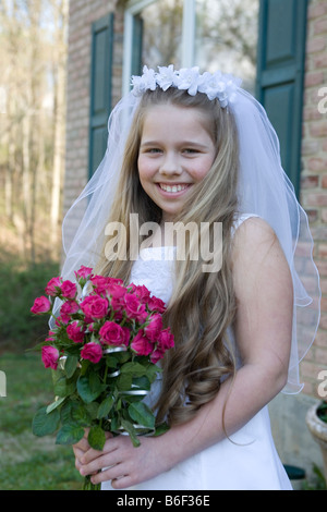 Enfant en robe de mariage après sa Première Communion Banque D'Images