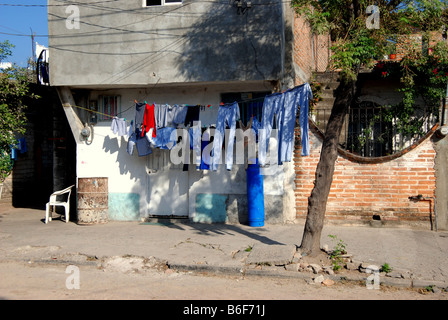 Laver le séchage sur les cordes à linge familial tendu en face de maisons modestes à Puerto Vallarta, Mexique Banque D'Images