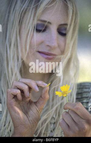 Blonde woman in love plumaison pétales de fleur jaune, Canaries, Fuerteventura Banque D'Images