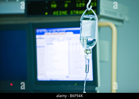 Flacon de perfusion en face d'un écran dans une salle d'opération Banque D'Images