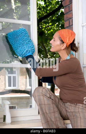 Young woman cleaning windows Banque D'Images