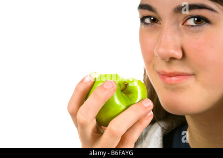 Close up portrait of horizontal d'une jeune adolescente ayant une alimentation verte juteuse Granny Smith Apple sur un fond blanc. Banque D'Images