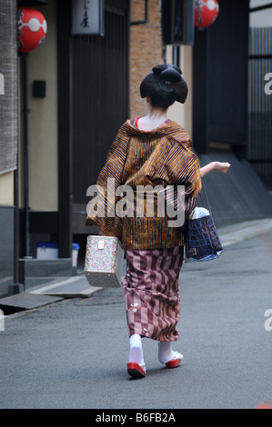 Une Maiko, une Geisha stagiaire, marchant dans le quartier de Gion en allant à l'Odori, Kyoto, Japon, Asie Banque D'Images