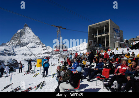 Les skieurs au repos dans le soleil à côté du téléphérique Klein Matterhorn sur la montagne, à l'exécuter, Steg Trockenen Mont Cervin Banque D'Images