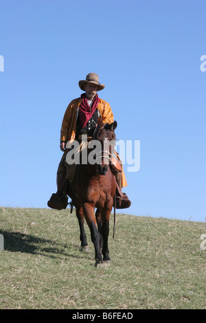 Un cowboy à cheval son cheval sur une colline au Texas Banque D'Images