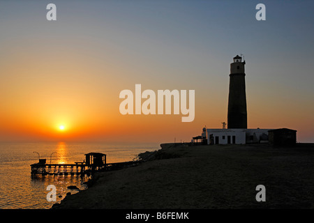 Phare et de la jetée, silhouette et coucher de soleil sur l'océan, le grand frère ou El Akhawein Kebir des îles Brothers, EGY Banque D'Images