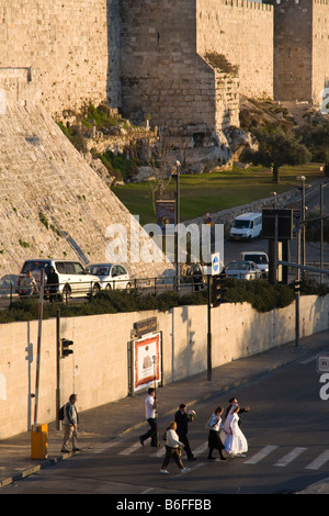 Israël Jérusalem Vieille Ville promenade des remparts de la ville promise traversant le stret, avec des murs bkgd Banque D'Images