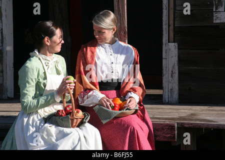 Deux jeunes femmes des prairies assis avec les fruits et légumes frais cueillis Banque D'Images