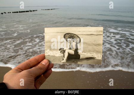 Main tenant une carte postale, ca. 1920, en face de la mer Baltique, hier et aujourd'hui Banque D'Images