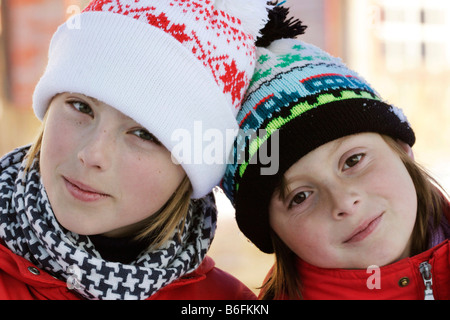 Deux soeurs, 9 et 12 ans, avec un chapeau en laine, à l'extérieur Banque D'Images