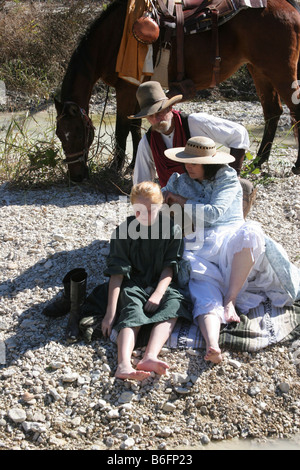 Une famille et le cheval sur le bord du cours d'eau bénéficiant de temps ensemble maman tressage des cheveux des filles Banque D'Images