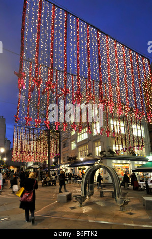 Les lumières de Noël et décorations au crépuscule à St Christophers Placer un shopping et manger à l'extérieur vue de la rue Oxford Street 'off' West End de Londres Angleterre Royaume-uni Banque D'Images