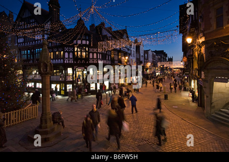 Chester Cheshire UK La Croix de la rue du Pont au-dessus de l'éclairage de Noël shoppers at Dusk Banque D'Images