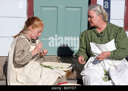 Une grand-mère et une jeune fille accrochage haricots sur leur longère porche dans le pays Banque D'Images