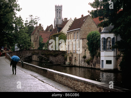 Marche tranquille sur un jour de pluie le long des canaux de Bruges, Belgique Banque D'Images