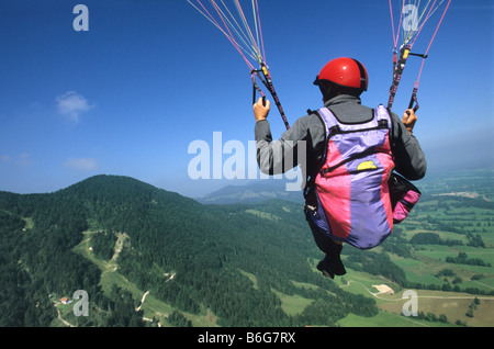 Pilote parapente Flyer vol au-dessus de sol près de Bad Tölz en Bavière en Allemagne avec deux poignées de direction Banque D'Images