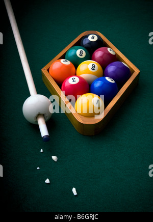 Boules de billard pool, disposés dans un rack à billes neuf sur un feutre vert table avec une vue surréaliste de la boule de choc briser Banque D'Images