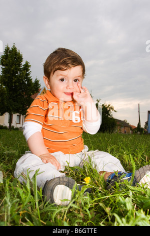 Baby Boy sitting in grass 10 mois Banque D'Images