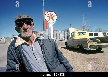 A 96 ans Mew Mexican Hispanic man wearing sunglasses et ayant besoin d'un rasage et sa vieille camionnette Banque D'Images