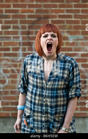 Une jeune rousse en colère colère red haired girl crier et crier hurler furieusement à l'appareil photo Banque D'Images