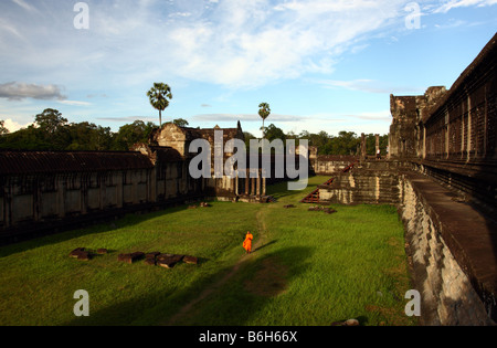 Le moine bouddhiste marchant dans la distance sur l'herbe à l'intérieur de temple d'Angkor Wat, au Cambodge Banque D'Images