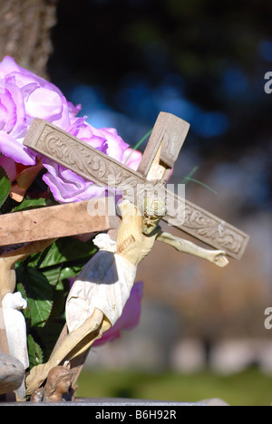 Crucifix dans une tombe dans un cimetière Banque D'Images