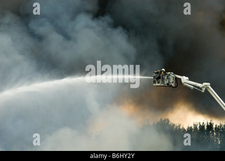 Un immense incendie avec des pompiers en action Banque D'Images