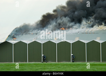 Un immense incendie avec des pompiers en action Banque D'Images