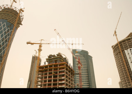 Les grues de construction au-dessus des gratte-ciel, low angle view, Doha, Qatar, Moyen-Orient Banque D'Images