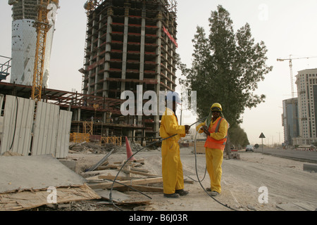 Deux travailleurs de la construction sur le site de construction de gratte-ciel, Doha, Qatar, Moyen-Orient Banque D'Images
