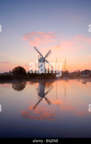 Thurne Moulin photographié sur un matin brumeux de palourdes au lever du soleil sur le parc national de Norfolk Broads. Banque D'Images