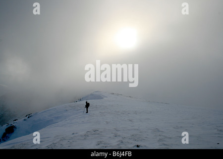 Fellwalking dans le nuage à Helvellyn couvertes de neige du plateau sommital, au nord-est du district du lac Banque D'Images