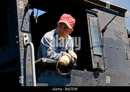 Ingénieur de formation à la recherche hors de la cabine sur le Old fashioned vintage train locomotive engine Banque D'Images