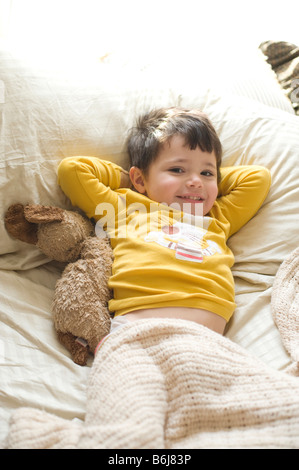 Trois ans salons et joue sur son lit des parents Banque D'Images