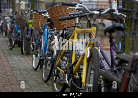 Pushbikes fixé contre une clôture en centre-ville de Cambridge. Banque D'Images