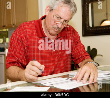 Handsome man documents signature à côté d'un paquet de billets Banque D'Images