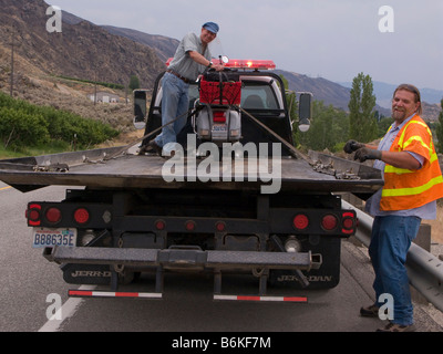 Robert Doc Morgan avec son Vespa P200E chargé sur un camion à plateau par le côté de l'US Highway 2, près de Wenatchee Washington Banque D'Images