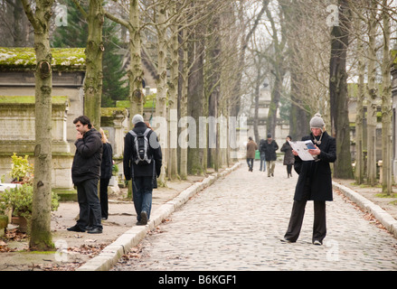 Un homme avec une carte qui montre où tous les gens célèbres sont enterrés au cimetière du Père-Lachaise à Paris Banque D'Images