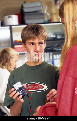Teen boy lit m expérience scientifique à l'école au cours de physique expérimentale. Banque D'Images