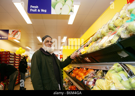 Asion man shopping in supermarket se situait à des fruits et légumes Article Banque D'Images